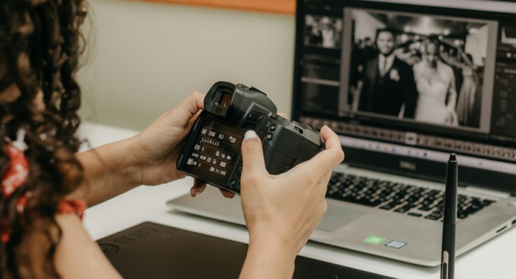 Una persona sosteniendo una c&aacute;mara frente a una laptop con una foto